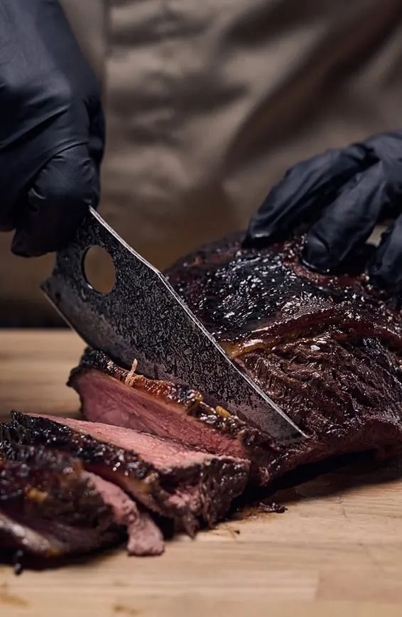 Matsato Osuren knife with a finger-hole grip in use, slicing meat